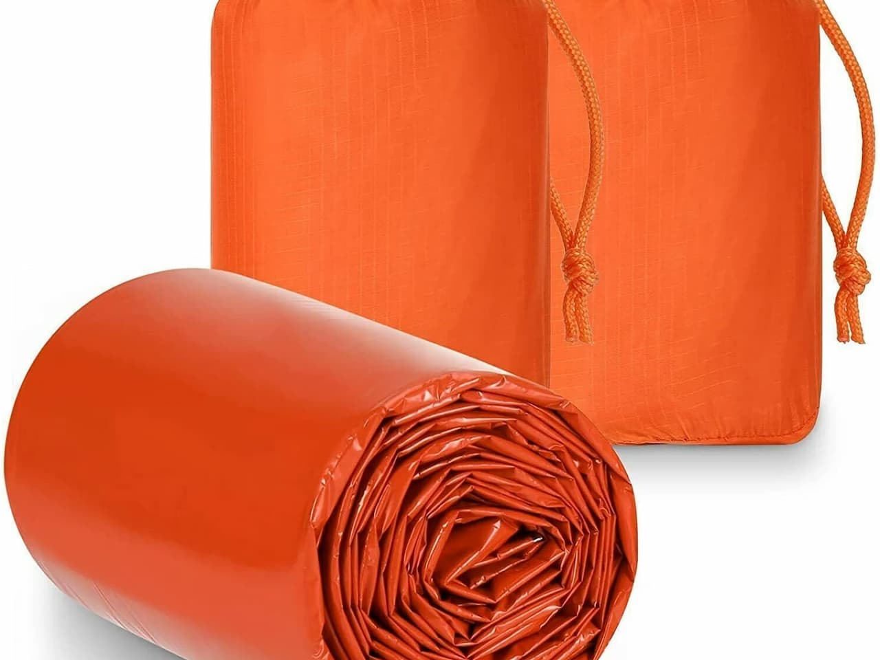 Two orange emergency sleeping bags in pouches and one rolled bivy sack partially unrolled