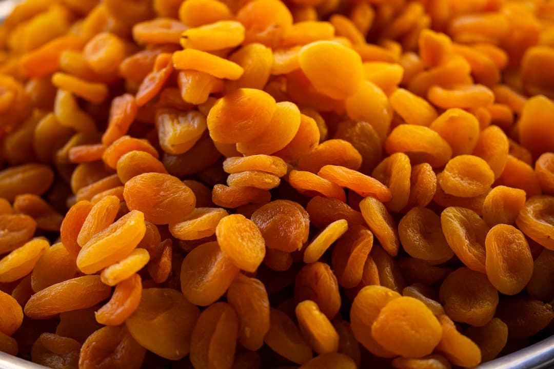 Pile of dried apricots in rich orange hues, close-up view