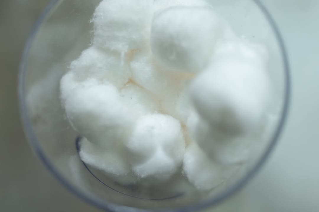 White cotton balls in a transparent container, viewed from above