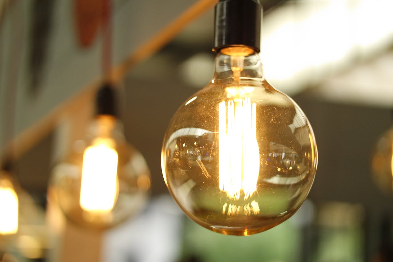 Close-up of glowing solar-powered LED filament bulbs hanging from a ceiling fixture indoors